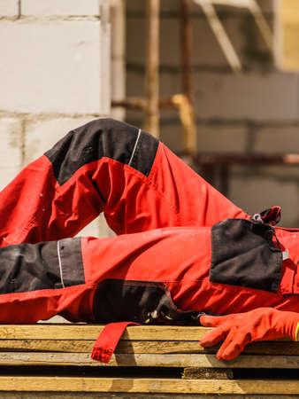 Unrecognizable person on construction site wearing protective worker red black pants trousersの写真素材