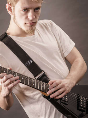 Man playing on electric guitar during gig. Musical instrument. Teenage boy having music hobby.