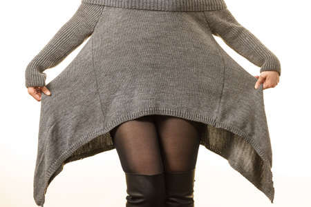 Unrecognizable woman wearing gray long top sweater tunic, black tights. Stylish, autumnal outfit.の写真素材