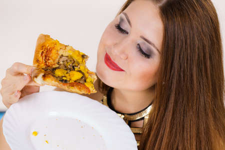 Young woman eating hot fresh pizza slice. Delicious fast food meal. People, italian cuisine concept.