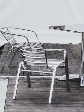 Steel metal made garden chairs and table in white party event tent.