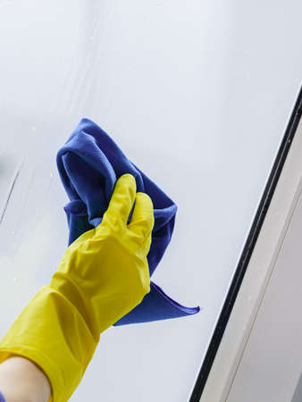 Person using cloth cleaning detergent to clean window glass. House clean products, household care...