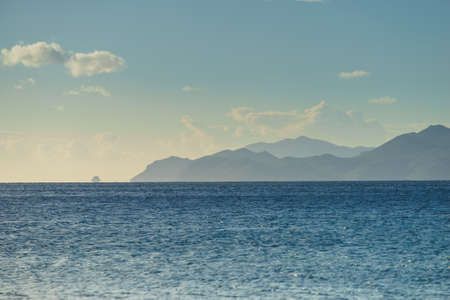 Beautiful sea landscape. Ocean water calmly waving next to rock coastline during summer warm...