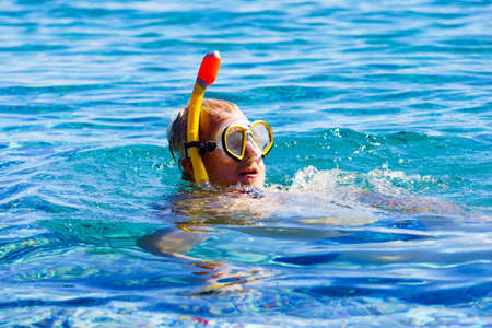 Man diver with snorkel equipment snorkeling mask tube in ocean water. Summer vacation swimming fun...