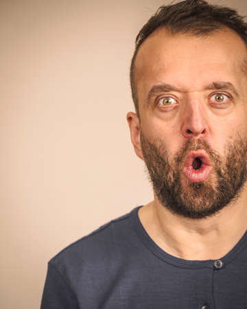 Shocked amazed beared adult guy having astonished full of disbelieve face expression.