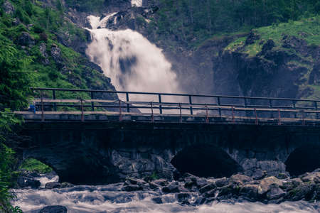 Norwegian landscape. Waterfall Latefoss Latefossen with stone arched bridge road, Odda Hordaland Norway. National tourist Hardanger road 13.の写真素材