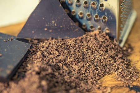 Grater, grated chocolate and chips curls closeup.の写真素材