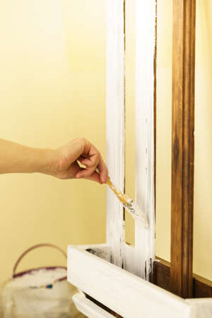 Home decor, color change, diy concept. Person renovating hanger made of wood.