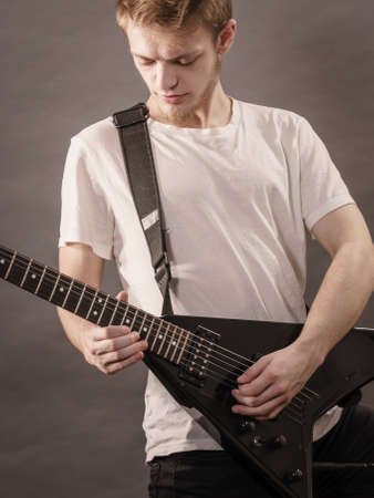 Man playing on electric guitar during gig. Musical instrument. Teenage boy having music hobby.