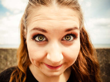 Close up of funny young teenage woman. Bizzare fish eye angle. Outdoor shot.