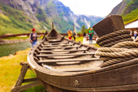 Old wooden viking boat on fjord shore. Mountains and Sognefjord. Tourism and traveling conceptの写真素材