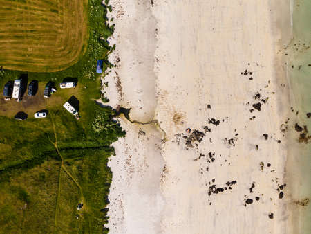 Top down view. Parking area with cars on sandy beach shore. Summertime.の写真素材