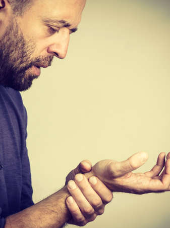 Man feeling pain in wrist having hand arm joints injury. Health rheumatism problems conept.の写真素材