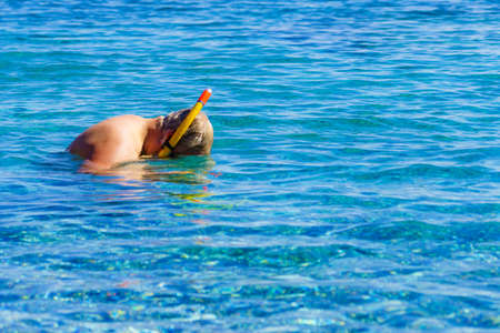 Man diver with snorkel equipment snorkeling mask tube in ocean water. Summer vacation swimming fun concept.の写真素材