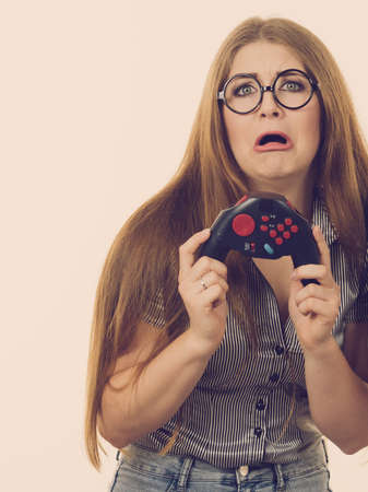 Young adult woman playing on the video console holding pad being very dissatisfied after loosing. Gaming gamers concept.の写真素材