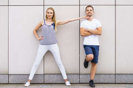 Date and love concept. Blonde young woman touching tender her boyfriend outdoors.
