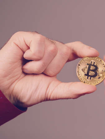 Man hand holding golden bitcoin coin sign, digital symbol of new virtual currencyの写真素材