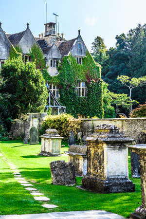 BIBURY, ENGLAND, UK - SEPTEMBER 21, 2014: graveyard in St Mary Parish Church and hotel in Bibury in Cotswold district on September 21, 2014, England.のeditorial素材