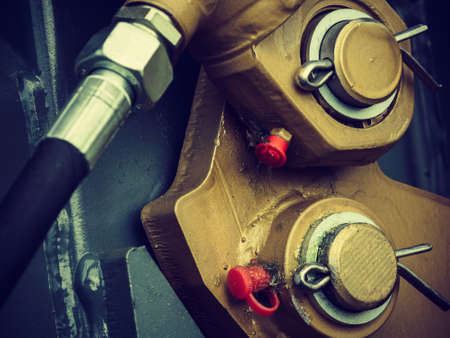 Construction machines concept. Detailed closeup of screw and bolts on yellow indrustrial machineryの写真素材