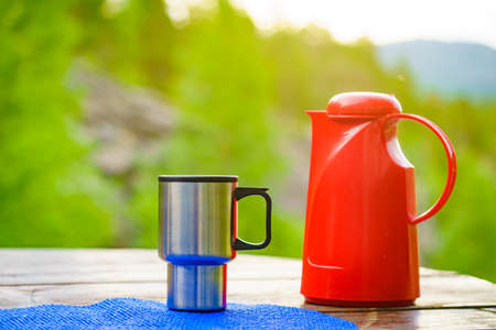 Picnic site table with thermal mug, norwegian mountains nature in the background.の写真素材