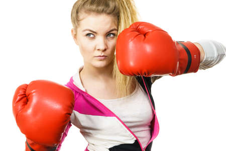 Sporty confident woman wearing red boxing gloves, fighting. Studio shot on white background.の写真素材