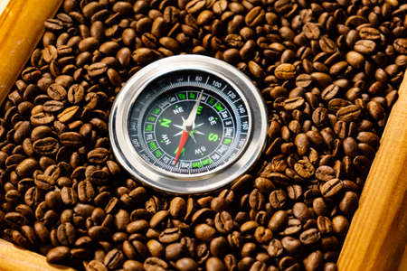 Roasted brown coffee beans with compass. Trade concept.の写真素材