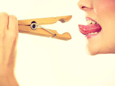 Language barrier, rumors, problems with expressing concept. Blonde woman having tongue in clothespinの写真素材