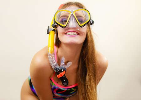 Woman wearing swimsuit with snorkeling mask having fun studio shot, Happy joyful girl dreaming about active summer vacation. Snorkeling swimming conceptの写真素材