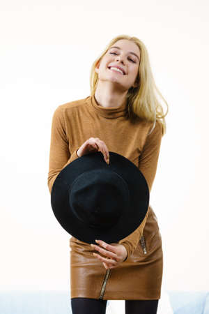Beautiful pretty woman wearing brown suede outfit and black sun hat. Female having fashionable outfit.の写真素材