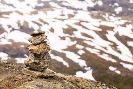Tourism vacation and travel. Stone stack in foreground and snowcapped mountain tops hills, view from...