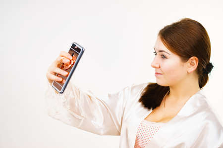 Young woman brown hair without makeup wearing underwear taking selfie photoの写真素材