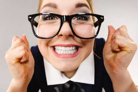 Crazy bizarre business woman or teacher wearing nerd eyeglasses. Female being energetic motivated, wide angle view.の写真素材