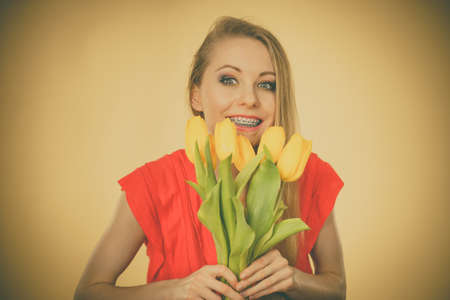 International women day, eight march. Beautiful portrait of pretty woman blonde hair with yellow tulips, fashion make up, elegant dress. Mothers day.の写真素材