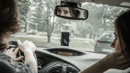 Man and woman during traveling trip. Couple, friends sitting inside vehicle car driving riding somewhere.の写真素材