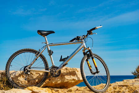 Bicycle outdoor parked on beach, blue sky sunny day. Holidays, sport and recreation.