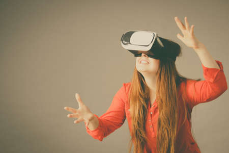 Young emotional woman wearing virtual reality goggles headset, vr box. Connection, technology, new...