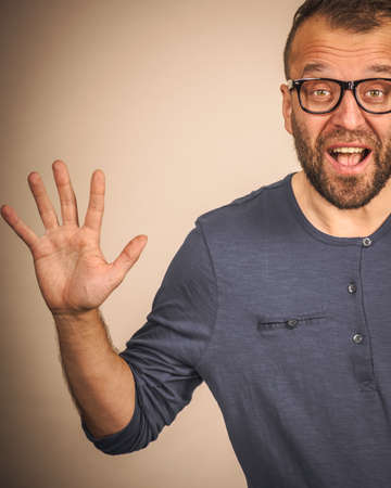 Funny adult man wearing eyeglasses, guy folling around gesturing with hands, trying to be scary. Positive emotions concept.の写真素材