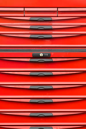 Red plastic box cabinet with black handles drawers. Objects made of plastic details.の写真素材