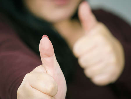 Adult happy big woman making thumb up gesture showing cool sign, on grey. Satisfaction success symbolの写真素材