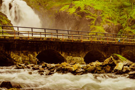Norwegian landscape. Waterfall Latefoss Latefossen with stone arched bridge road, Odda Hordaland Norway. National tourist Hardanger road 13.の写真素材