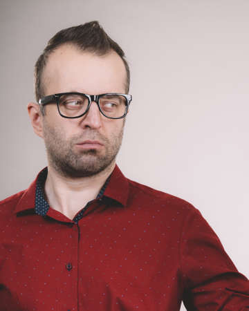 Businessman looking guy wearing big eyeglasses. Adult man in red casual shirt.の写真素材