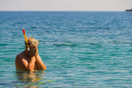 Man diver with snorkel equipment snorkeling mask tube in ocean water. Summer vacation swimming fun concept.の写真素材