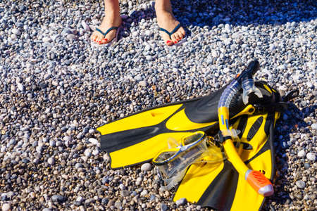 Unrecognizable mature female with snorkel equipment flippers and snorkeling mask tube on beach sea shore. Summer vacation swimming fun concept.の写真素材