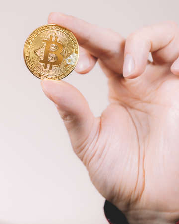 Man hand holding golden bitcoin coin sign, digital symbol of new virtual currencyの写真素材