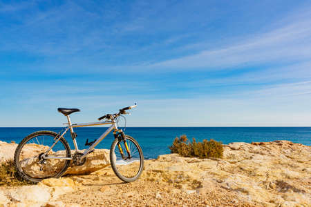 Bicycle outdoor parked on beach, blue sky sunny day. Holidays, sport and recreation.の写真素材