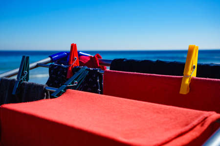Camping on beach, adventure concept. Clothes hanging to dry on laundry line outdoor against sea.