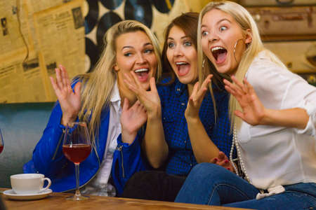 Happy girls best friends drinking coffee and alcohol in bar club, having fun. People, leisure, friendship and entertainment conceptの写真素材