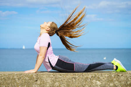 Fit attractive young woman wearing fashionable outfit working out being active outside. Practice...