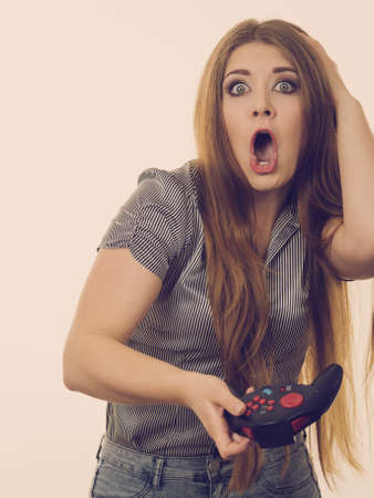 Young adult woman playing on the video console holding pad being very into game. Gaming gamers...