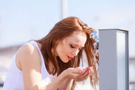 Woman drinking clean water from street tap